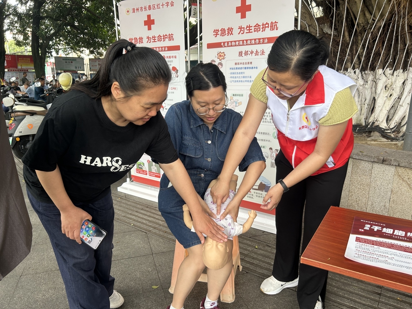 4、红十字志愿者与居民互动讲解小孩海姆立克急救法.jpg